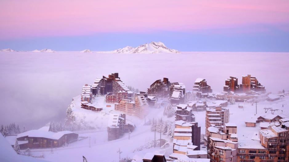Edifici modernisti in montagna, avvolti nella nebbia.