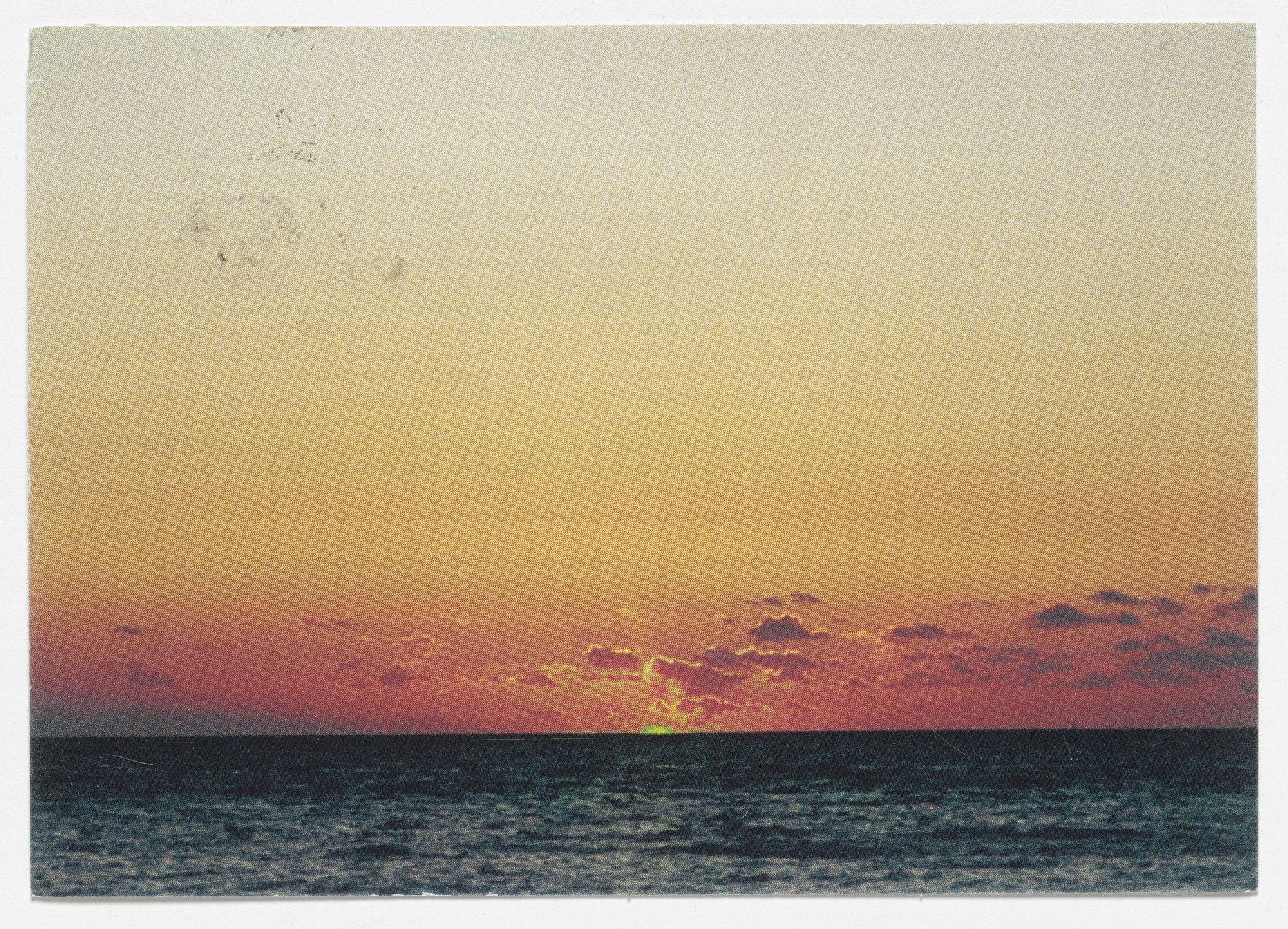 Un tramonto sul mare. Il sole emette toni di colore verde sull'acqua scura È The Green Ray dell'artista Tacita Dean.