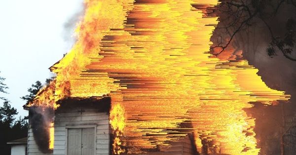 Immagine glitch di una casa che va a fuoco.