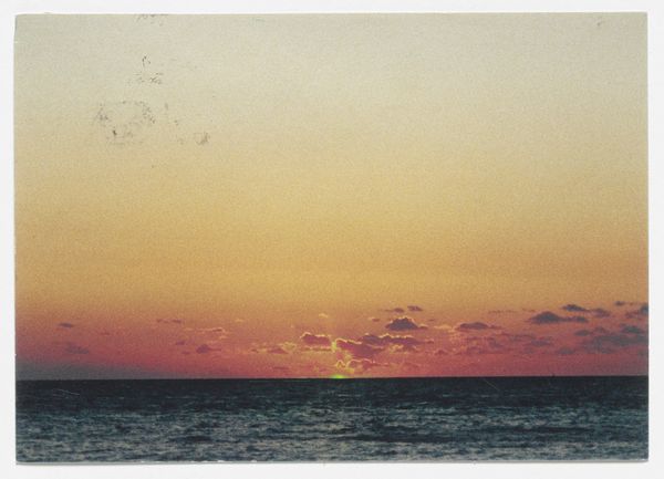Un tramonto sul mare. Il sole emette toni di colore verde sull'acqua scura È The Green Ray dell'artista Tacita Dean.